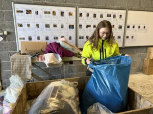 Student Caroline står med søppelsekker med klær som er samlet inn på Årabrot miljøpark